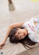 A woman laying on top of a bed next to a table.